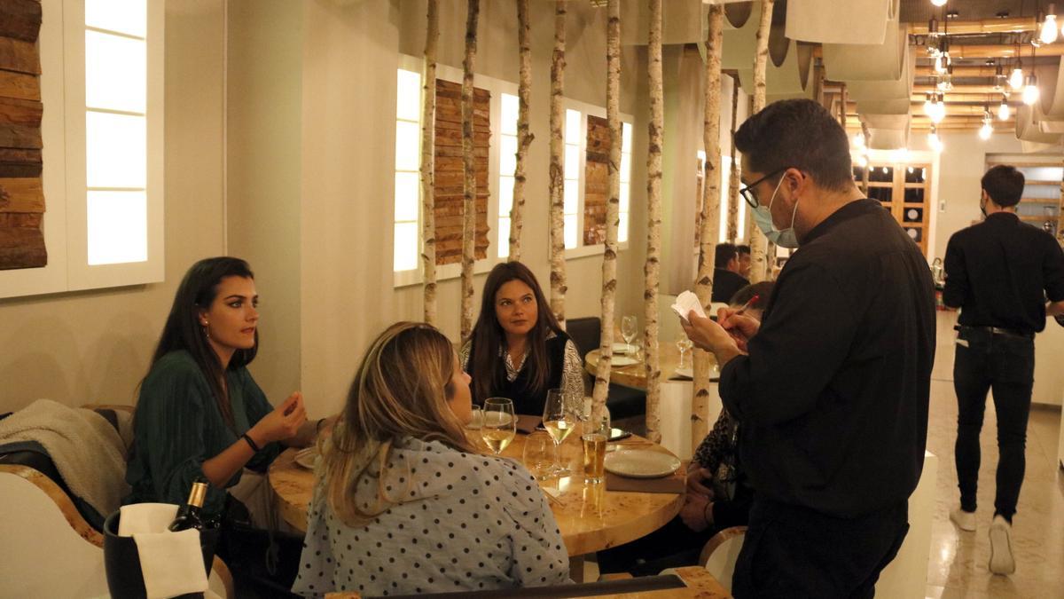 Pla obert d&#039;un cambrer agafant la comanda a quatre noies que sopen al restaurant Macao de Lleida