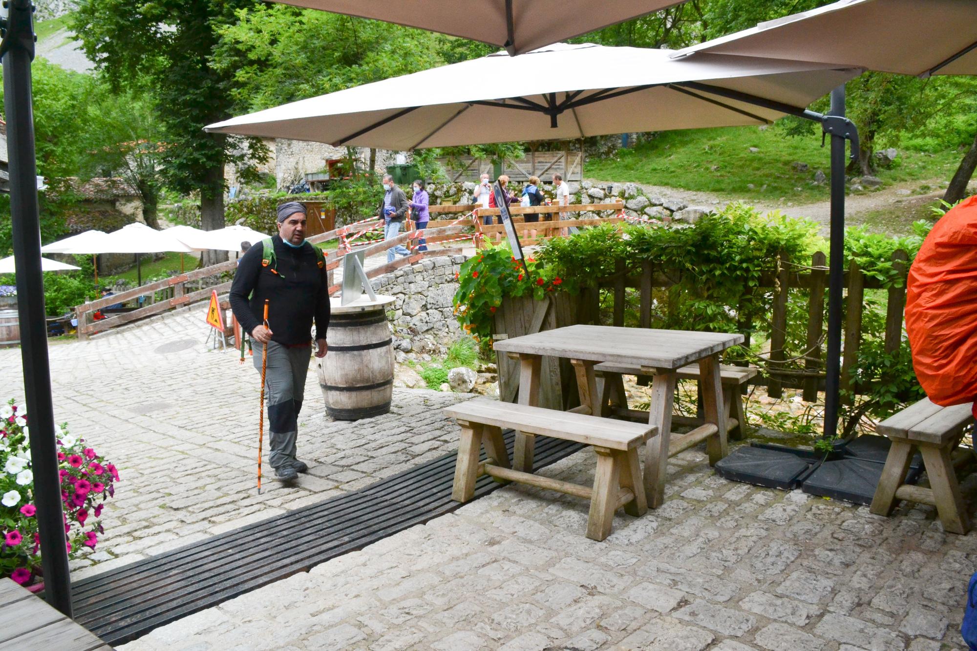 Un turista llega a uno de los bares que abren sus puertas en Bulnes.