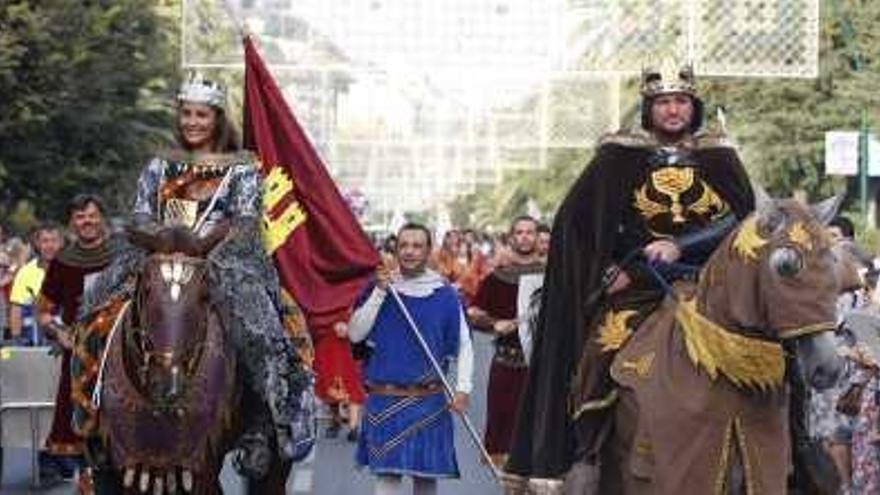 Los Reyes Católicos montados a caballo mientras pasean por las calles.