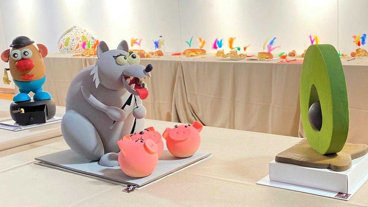 Un lobo a punto de comerse tres cerditos, de L’Atelier (Barcelona), ganador de la Mejor Mona de Pascua 2023 en la categoría de chocolate, con algunas piezas presentadas a concurso este lunes en el centro cultural La Farinera del Clot.