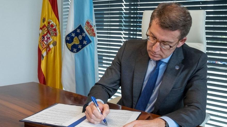 Feijóo, firmando la carta a la militancia en la que anuncia su dimisión como presidente del PPdeG.