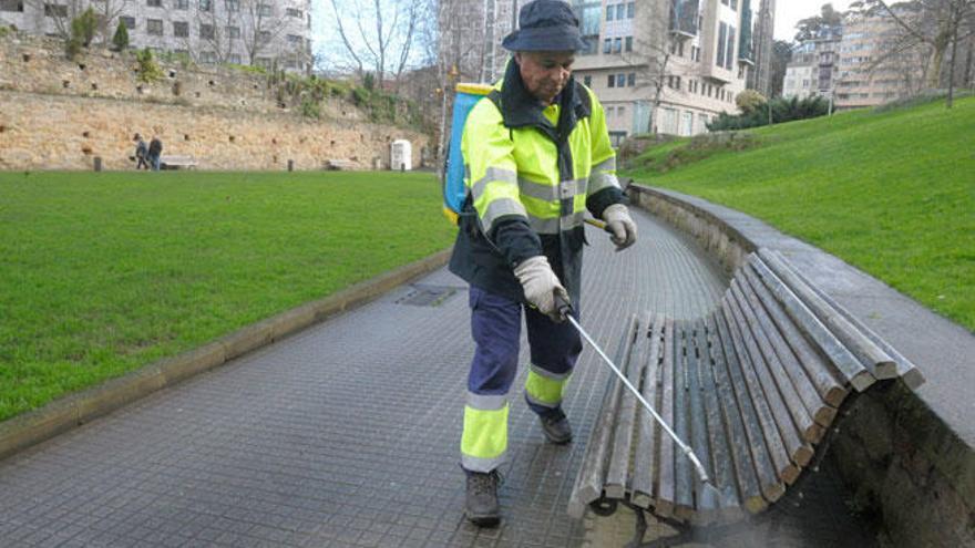 Un operario del servicio de limpieza haciendo uso del vinagre en el parque de los Puentes el viernes.