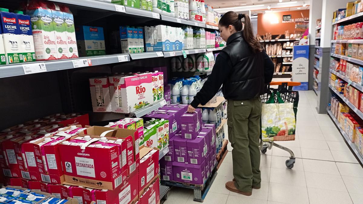 Una clienta cogiendo leche en un supermercado,