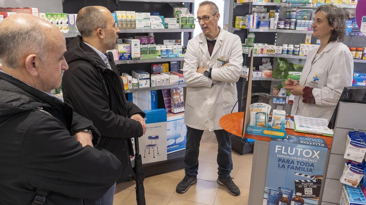 Sixto i Aloy escolten el farmacèutic Carles Garzón, a la farmàcia de la Font