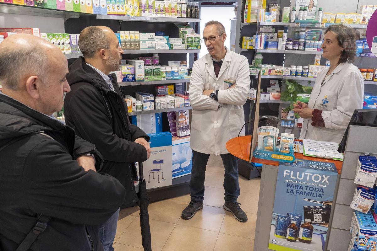 Sixto i Aloy escolten el farmacèutic Carles Garzón, a la farmàcia de la Font