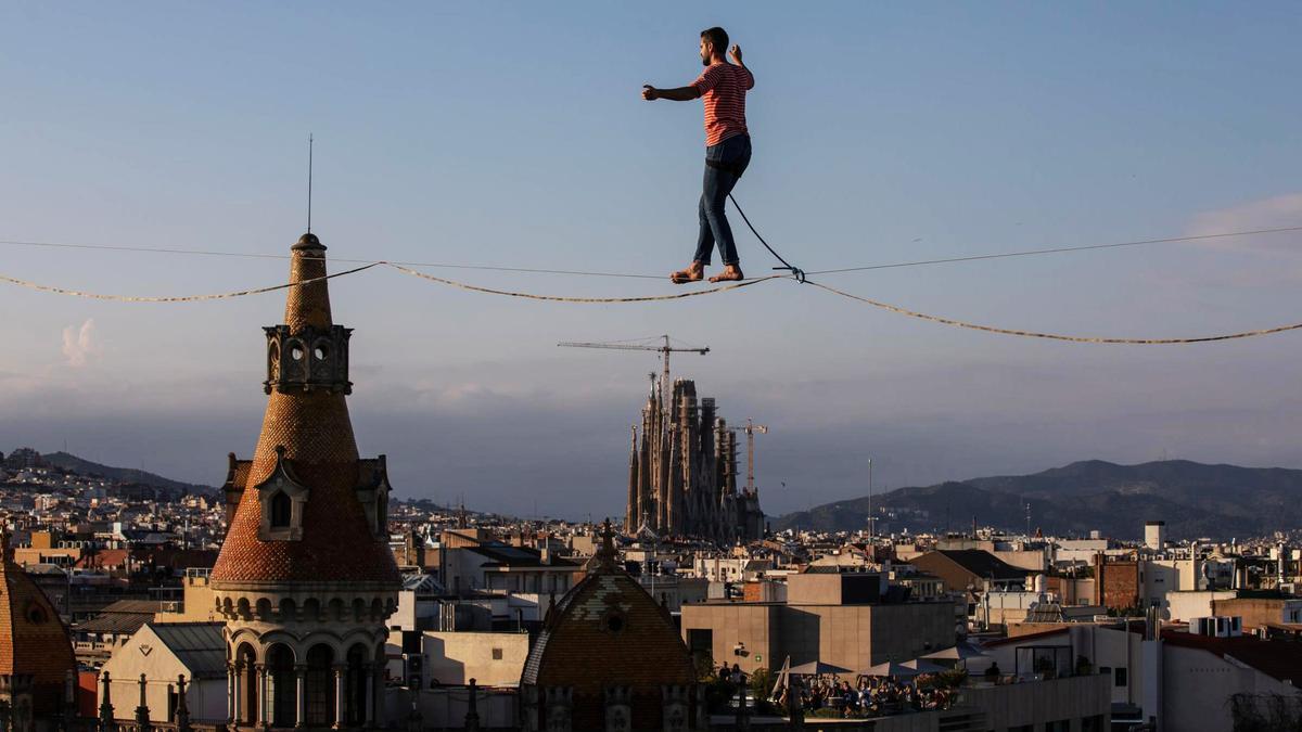 A 70 metros sobre el suelo. El funambulista Nathan Paulin cruza la plaza de Catalunya de Barcelona, de ida y vuelta, en una performance espectacular para inaugurar el Grec