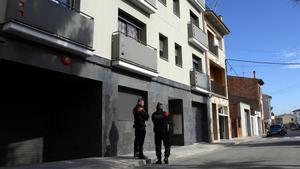 Dos mossos custodian la entrada en un domicilio de Vic, este miércoles por la mañana. 