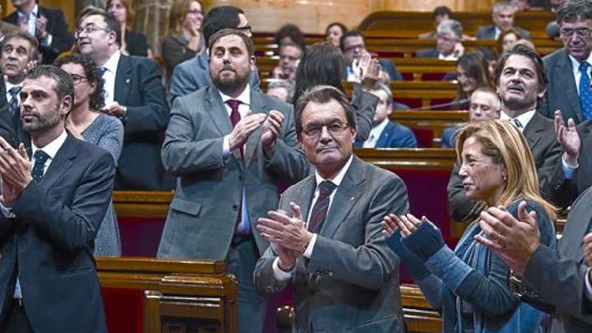 Artur Mas, entre otros miembros del Govern y diputados de CiU y ERC, aplaude tras la votación a favor de la declaración de soberanía, ayer.