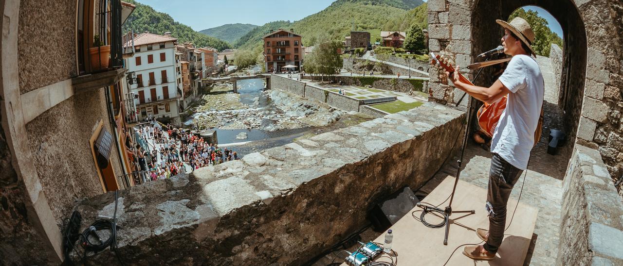 Ramon Mirabet actuant sobre el Pont Nou de Camprodon amb el públic a baix.