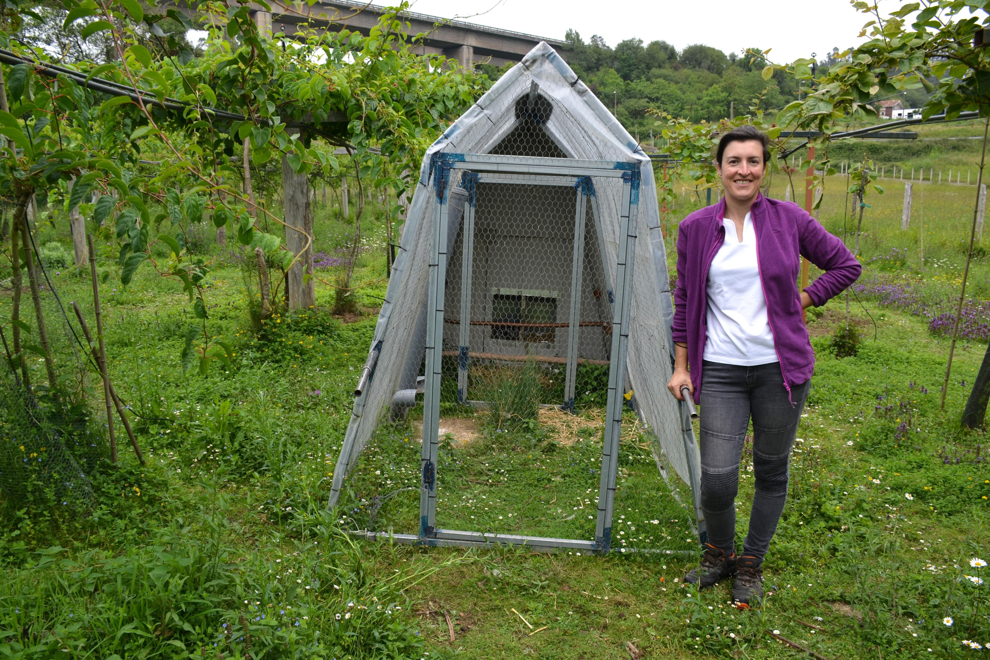 Cristina Secades junto al gallinero portátil, para sus gallinas de pinta pinta asturiana.