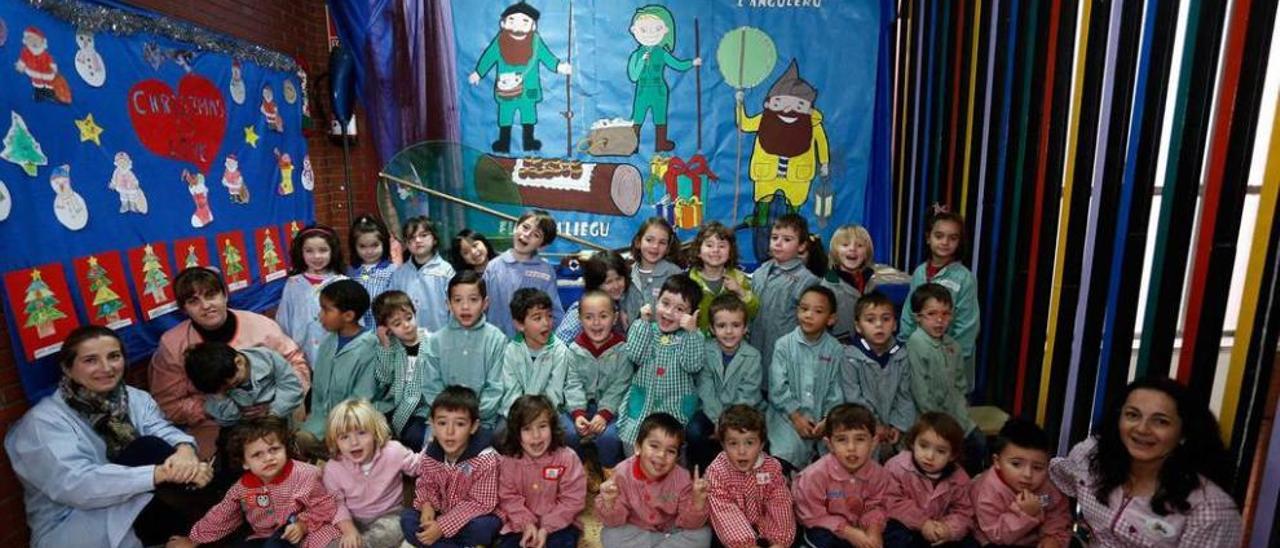 Los alumnos de Educación Infantil del colegio Marcelo Gago, ante el cartel de l&#039;Anguleru y otras tradiciones asturianas que decoran una de las estancias comunes del centro.