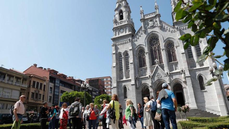 Un grupo de turistas durante una visita guiada por la ciudad, delante de la iglesia de Santo Tomás de Cantorbery, en el centro de Avilés y próxima al barrio de Sabugo. | Mara Villamuza