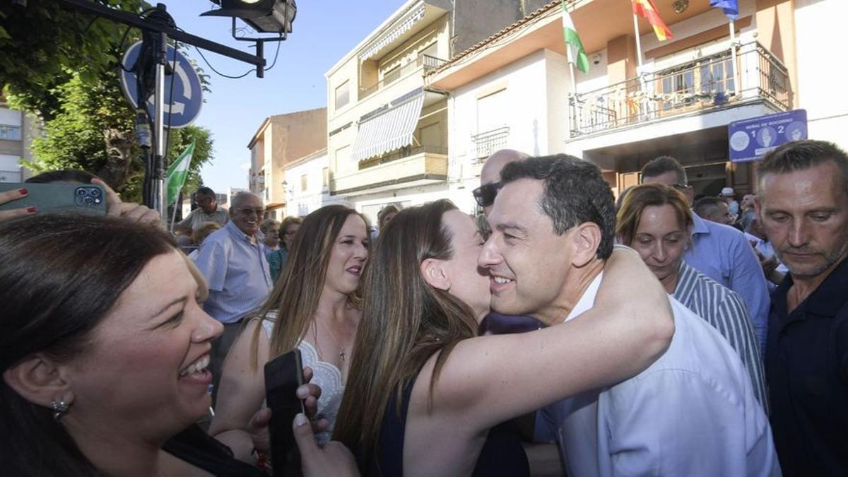 El presidente de la Junta de Andalucía y candidato del PP, Juanma Moreno (d), en un acto en Churriana de la Vega, Granada, este jueves.