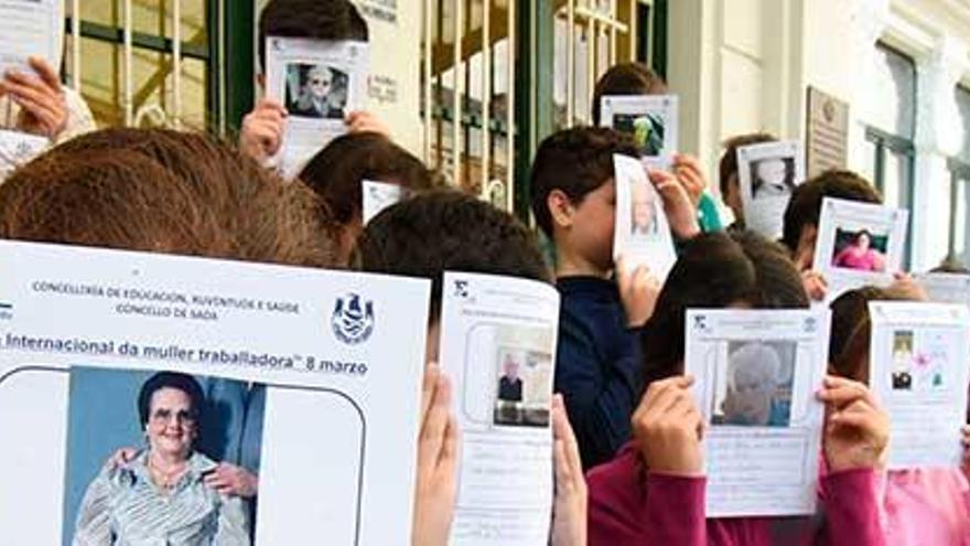 Escolares del colegio Sada y sus Contornos muestran las fichas dedicadas a sus bisabuelas.