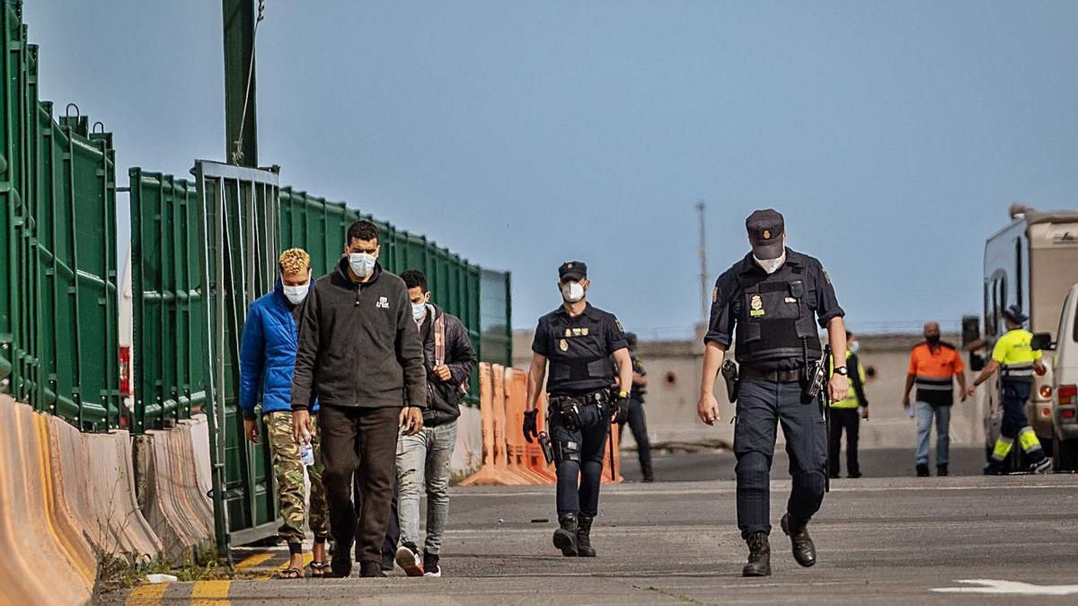 Varios migrantes son conducidos por la Policía hasta el exterior del Puerto de Santa Cruz de Tenerife.