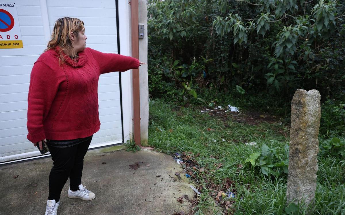 La vecina señala la zona descampada donde se halló la maleta.