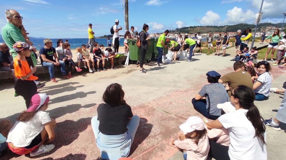 Un momento de la charla, con las bolsas de residuos recogidos en la arena.   | // DANI MARCOS