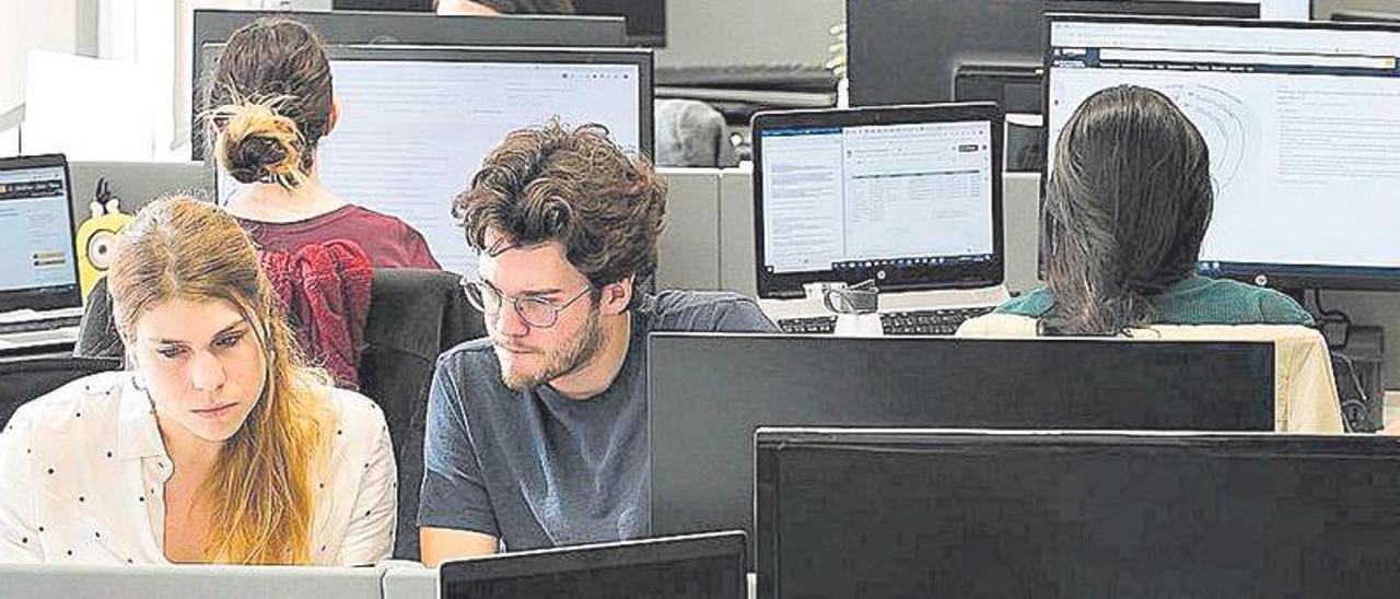 Jóvenes en sus puestos de trabajo en una empresa de Barcelona.