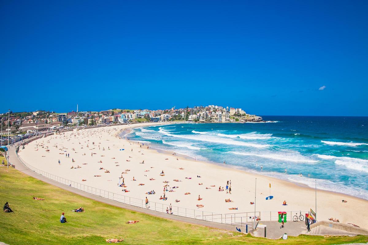 Bondi Beach es la playa más famosa de Sídney (Australia), un amplio arenal dorado de un kilómetro en forma de media luna famoso por sus olas, su vibrante ambiente surfista y su estilo de vida activo