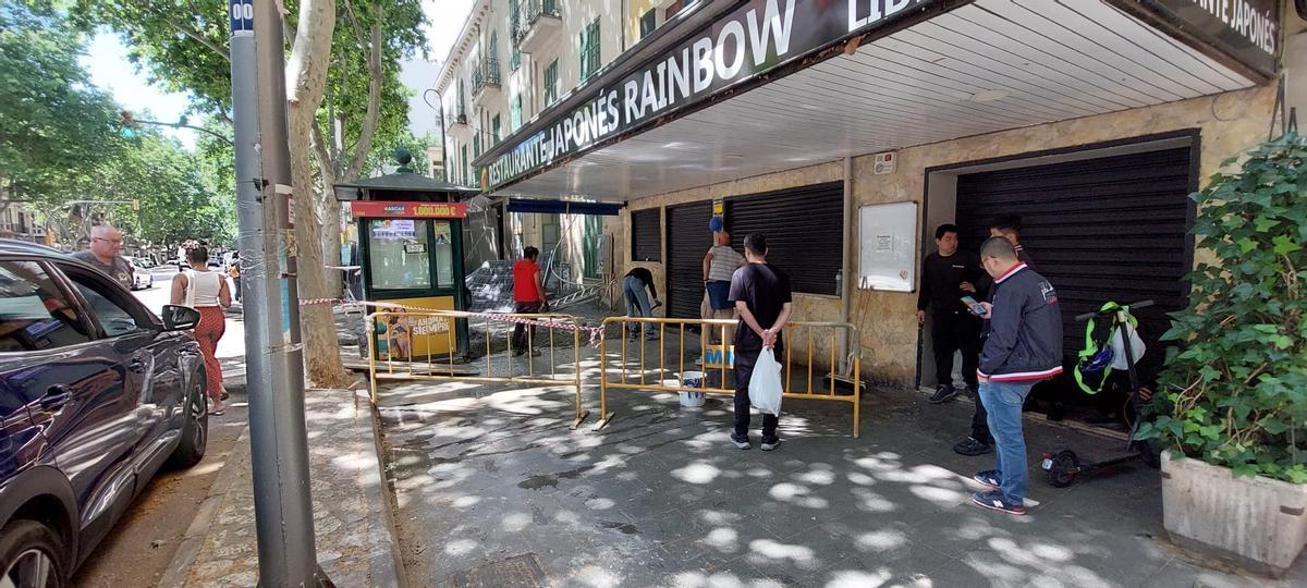 Trabajadores del restaurante Rainbow aguardan en la entrada bloqueada del local.