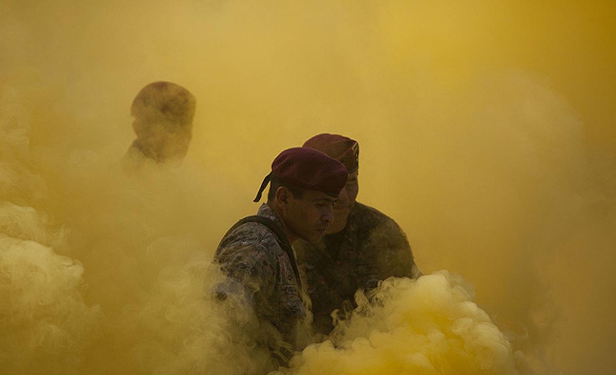 Membres d’una unitat militar especial entre el fum de les torxes durant una cerimònia de graduació a Poptún (Guatemala).