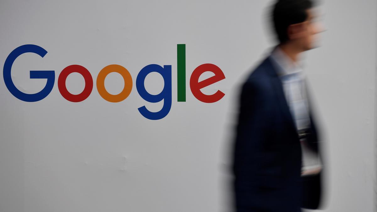 Un hombre pasa por delante del logo de Google.