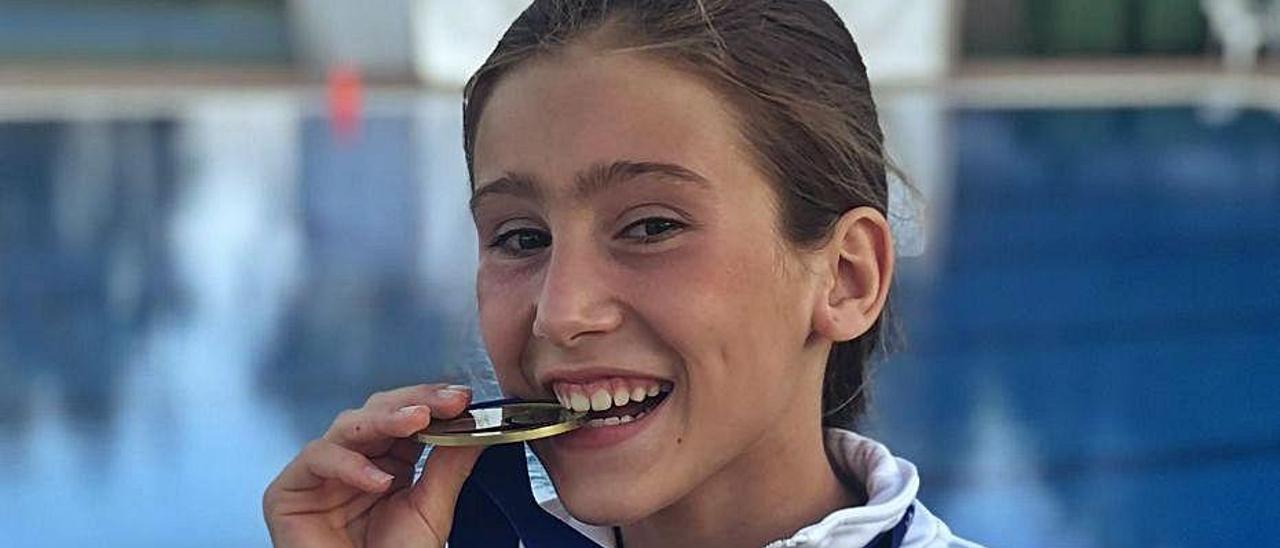Sofía Balogh, del CN Eivissa, muerde la medalla de oro. | CNE