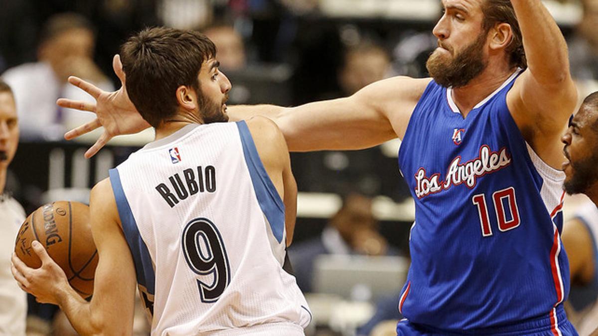 Ricky Rubio trata de deshacerse Spencer Hawes para pasar el balón, en el partido entre los Timberwolves y los Clippers