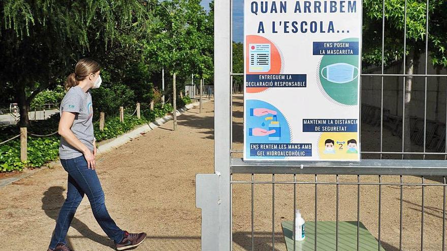 Cartell informatiu a la porta d&#039;una escola de Banyoles el dia de reobertura al juny.