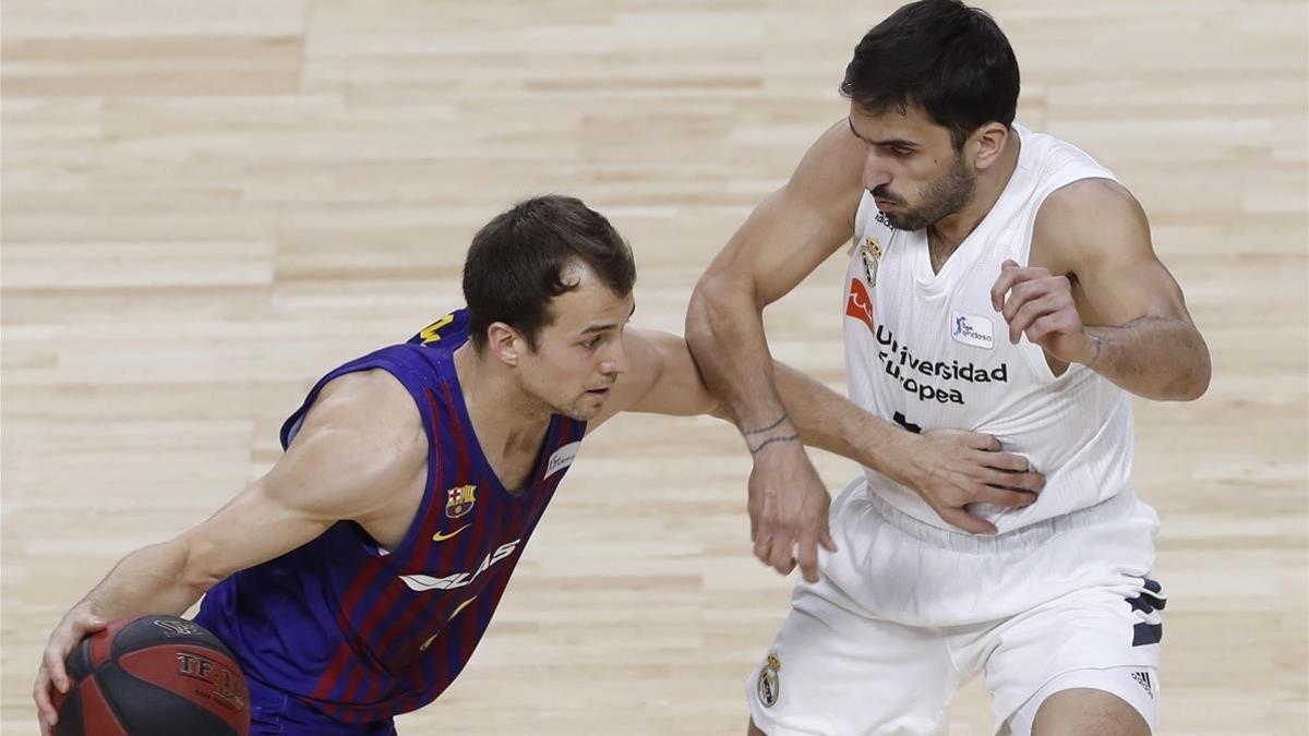 Kevin Pangos intenta superar la oposición de Campazzo en el partido