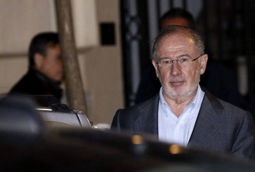 El exvicepresidente del Gobierno Rodrigo Rato (d) abandona su despacho cuatro horas después de que comenzara el registro por parte de los agentes de la Agencia Tributaria y de Aduanas, que han sacado una veintena de cajas con documentación.