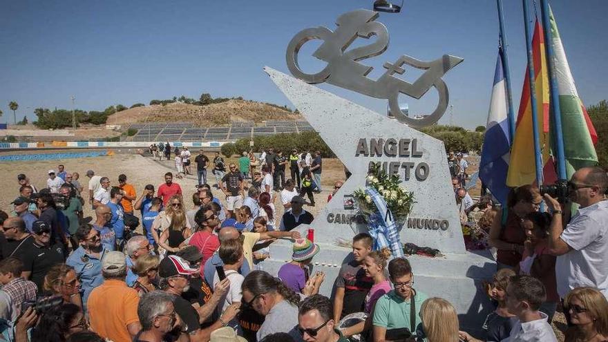 Aficionados en la curva del circuito de Jerez en la que está situada la escultura que recuerda los 12+1 títulos mundiales de Ángel Nieto. // Román Ríos