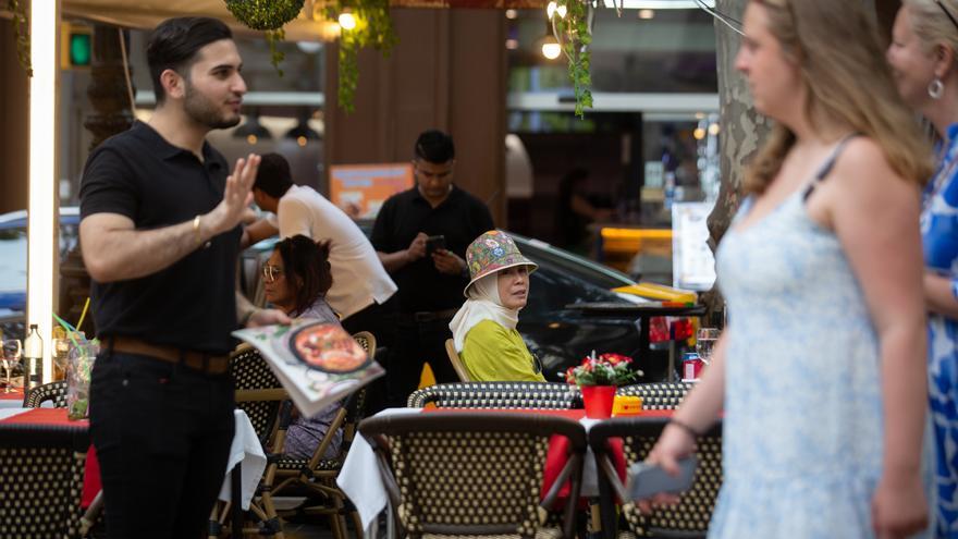 Una persona sentada en una mesa en la zona de las Ramblas de Barcelona.