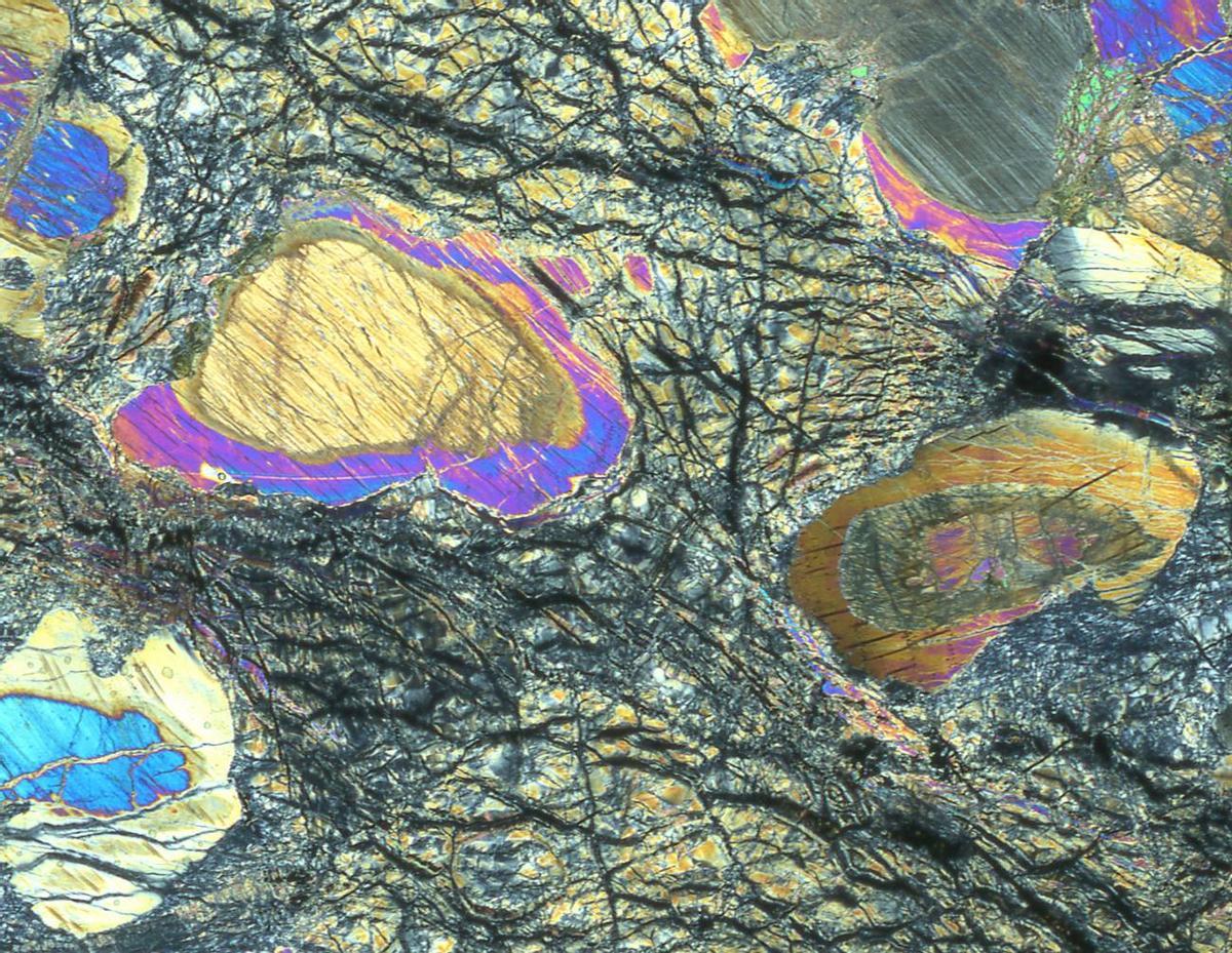 Roca del manto recuperada durante la Expedición 399 del IODP vista con un microscopio petrográfico.