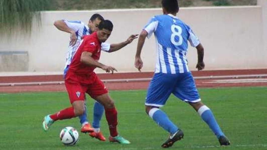 El ariete Sergio Narváez, uno de los dos bigoleadores del Marbella, controla el esférico ante dos jugadores del Jumilla .