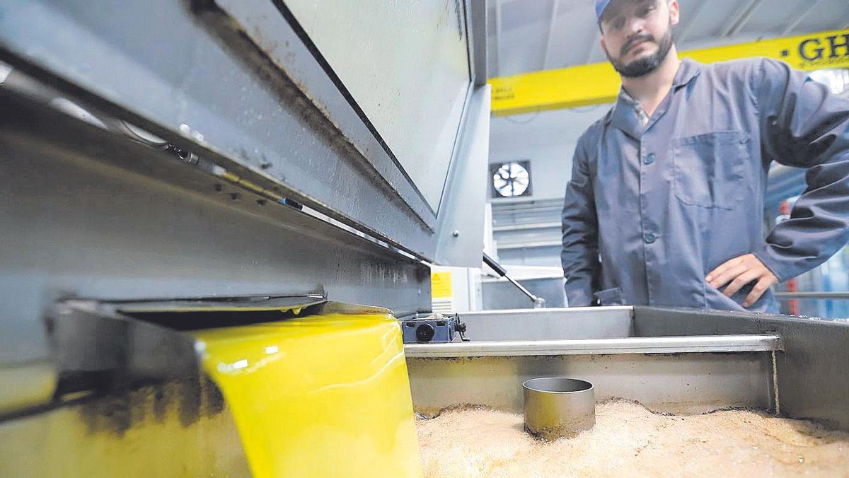 Un trabajador de una almazara observa la salida de uno de los primeros aceites del año.