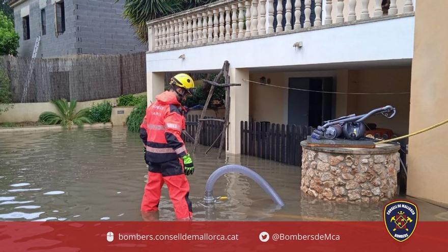 Bombers de Mallorca achican agua en una de las inundaciones en la isla causadas por la lluvia.