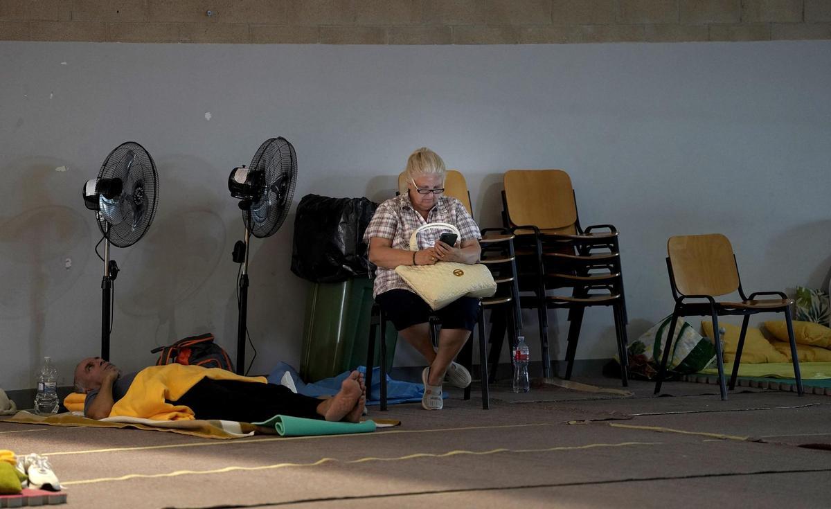 Vecinos de pueblos desalojados por los incendios, en el polideportivo de Villamanta.