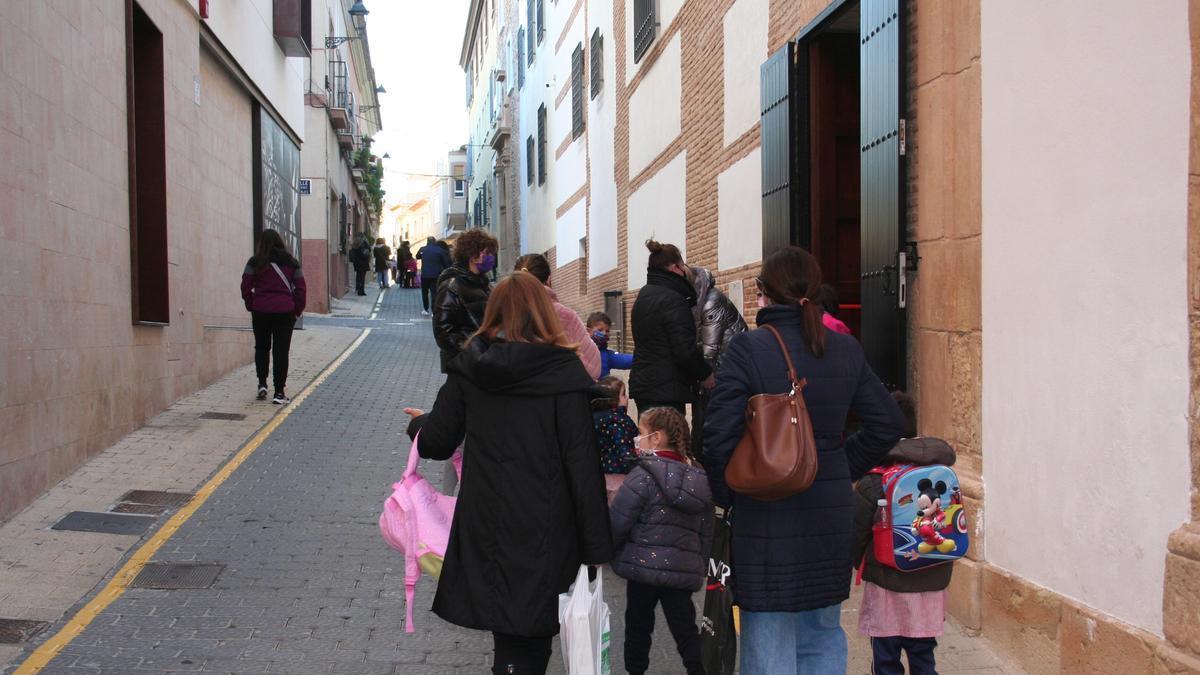 Un grupo de padres con sus hijos camino del colegio Madre de Dios, este lunes.