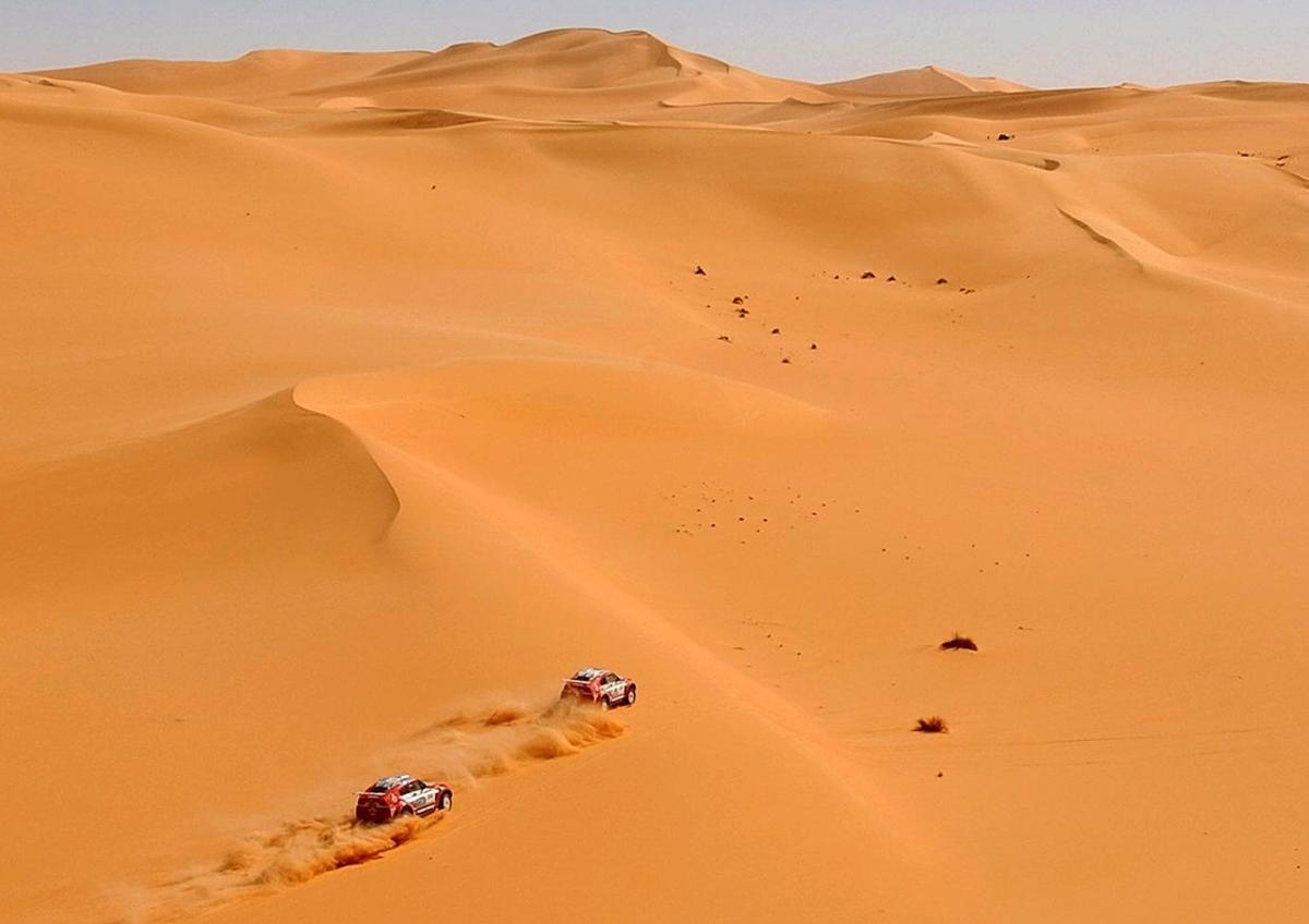 Mitsubishi teammates Hiroshi Masuoka of Japan  right  and Stephane Peterhansel of France speed side by side during the eighth stage of the Dakar rally between Ghat and Sabha in southern Libya  Thursday  Jan  9  2003  The Dakar rally will end on Jan  19 in Egypt   AP Photo Presse-Sports  Bernard Papon     MAGAZINES OUT