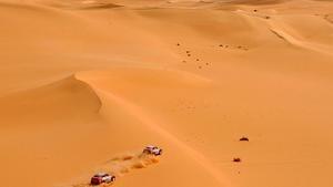 Mitsubishi teammates Hiroshi Masuoka of Japan  right  and Stephane Peterhansel of France speed side by side during the eighth stage of the Dakar rally between Ghat and Sabha in southern Libya  Thursday  Jan  9  2003  The Dakar rally will end on Jan  19 in Egypt   AP Photo Presse-Sports  Bernard Papon     MAGAZINES OUT