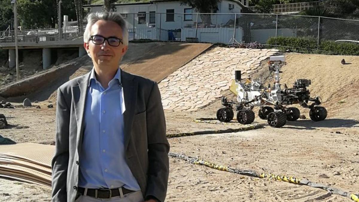 Tirso Velasco, en el exterior del laboratorio de propulsión a reacción de la NASA, en California, con un rover detrás.