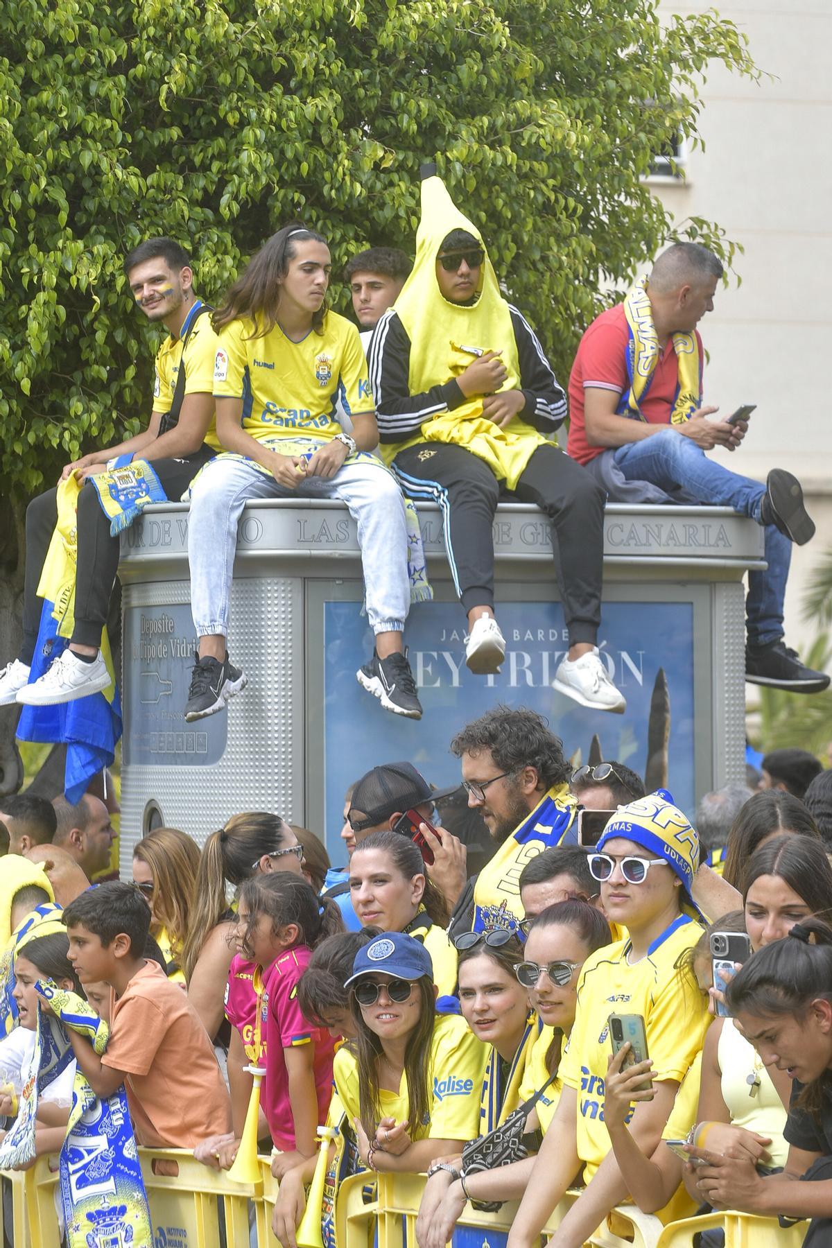 Un fiel de la UD vestido de plátano espera el paso de la guagua por Fondos de Segura.