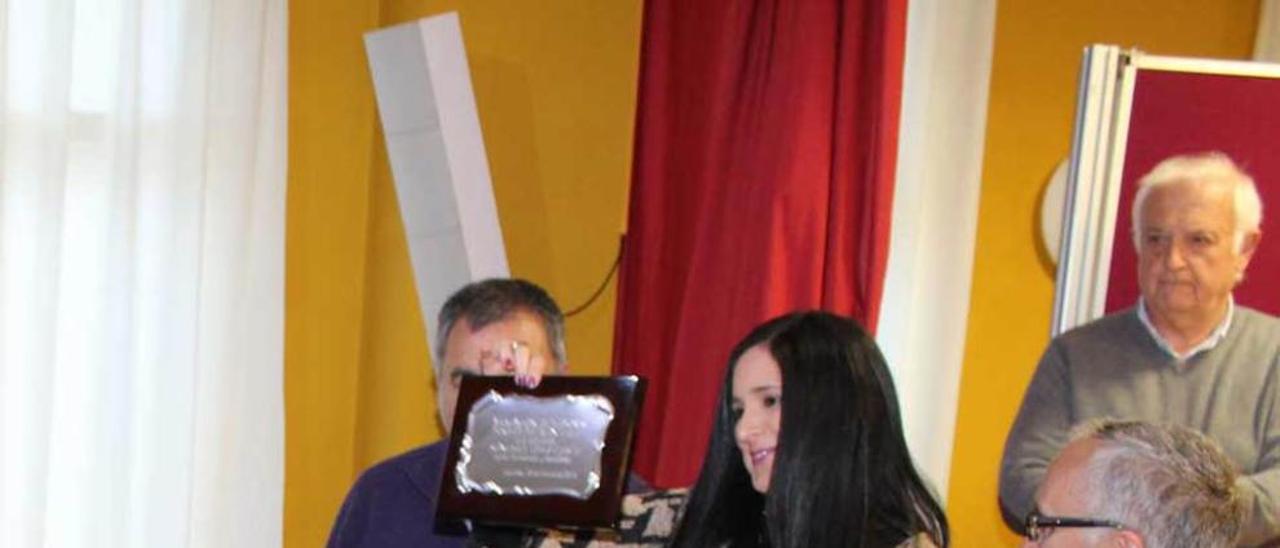 Cristina López, hija del docente, recoge la placa de manos del presidente de la asociación, José Antonio Villar.