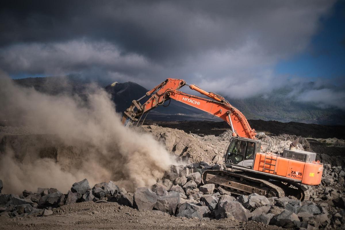 Imagen de una excavadora trabajando en una zona afectada por las coladas del volcán Tajogaite, en la isla de La Palma.