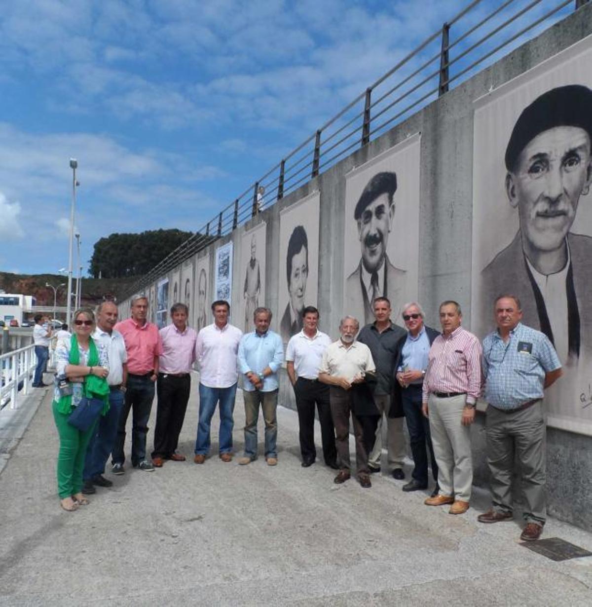 La edil Cecilia Tascón, José Antonio González, Fernando Manuel García, Tito Aramendi, Cuco Fernández, José Manuel Muñiz, Armando Velasco, Alfredo Menéndez, Alberto López, Alberto Vizcaíno, Ángel Riego y Dimas García, ayer, ante la exposición del puerto candasín. | mónica g. salas