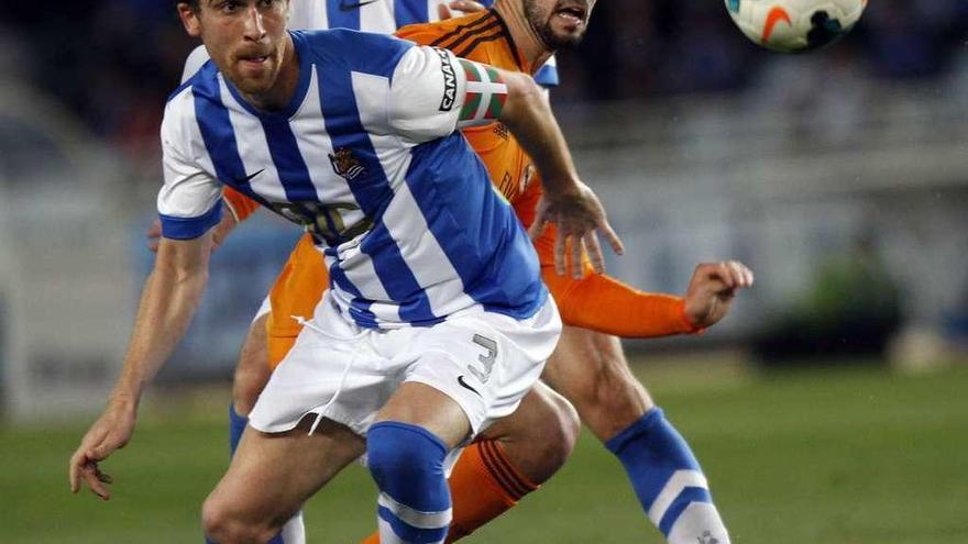 Mikel González disputa un balón con Isco.