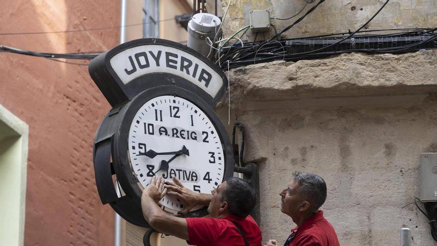 El centenario reloj dels Quatre Cantons de Xàtiva vuelve a la vía pública restaurado cuatro meses después de su caída