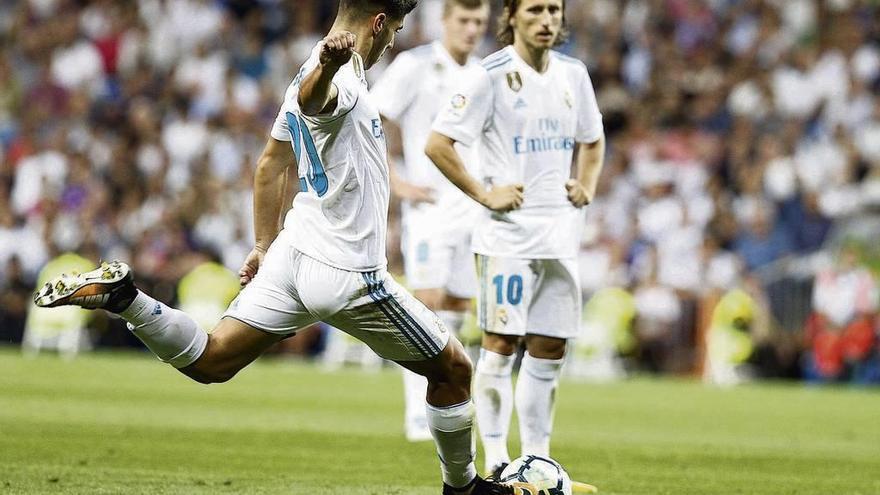 Marco Asensio lanza la falta con la que anotó su segundo gol, con Modric y Kroos siguiendo el golpeo de su joven compañero. // Javier López