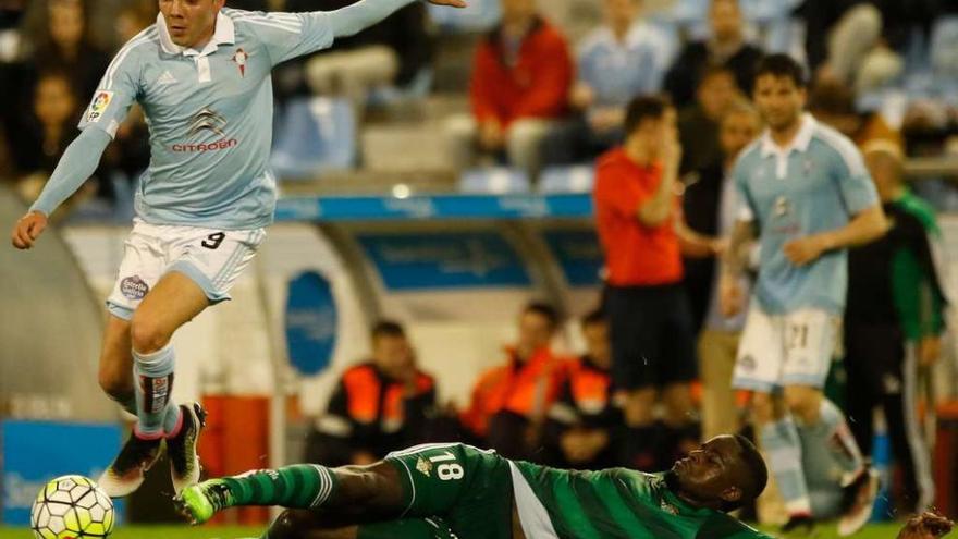 Iago Aspas avanza con el balón tras superar al bético N&#039;Diaye, que se tira al suelo, durante el partido del pasado sábado ante el Betis en el estadio de Balaídos. // Ricardo Grobas